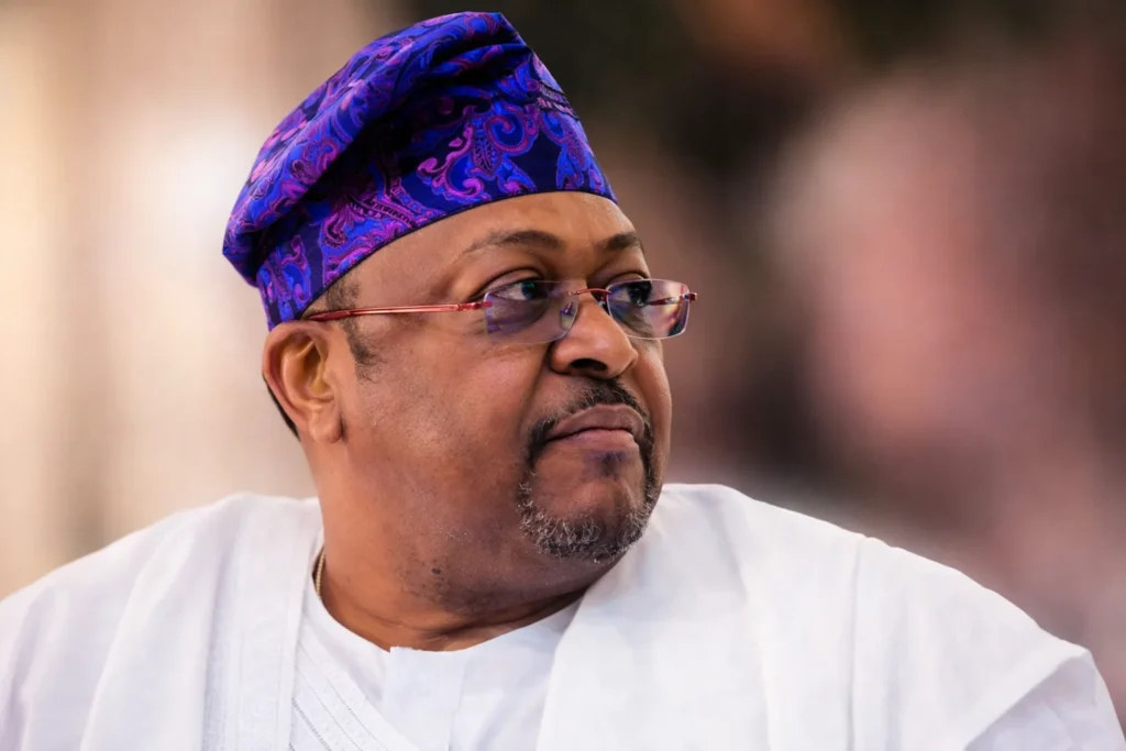 Mike Adenuga portrait showing the billionaire’s age, family, education, net worth, biography, state of origin, religion, first wife, children, and mansion.”